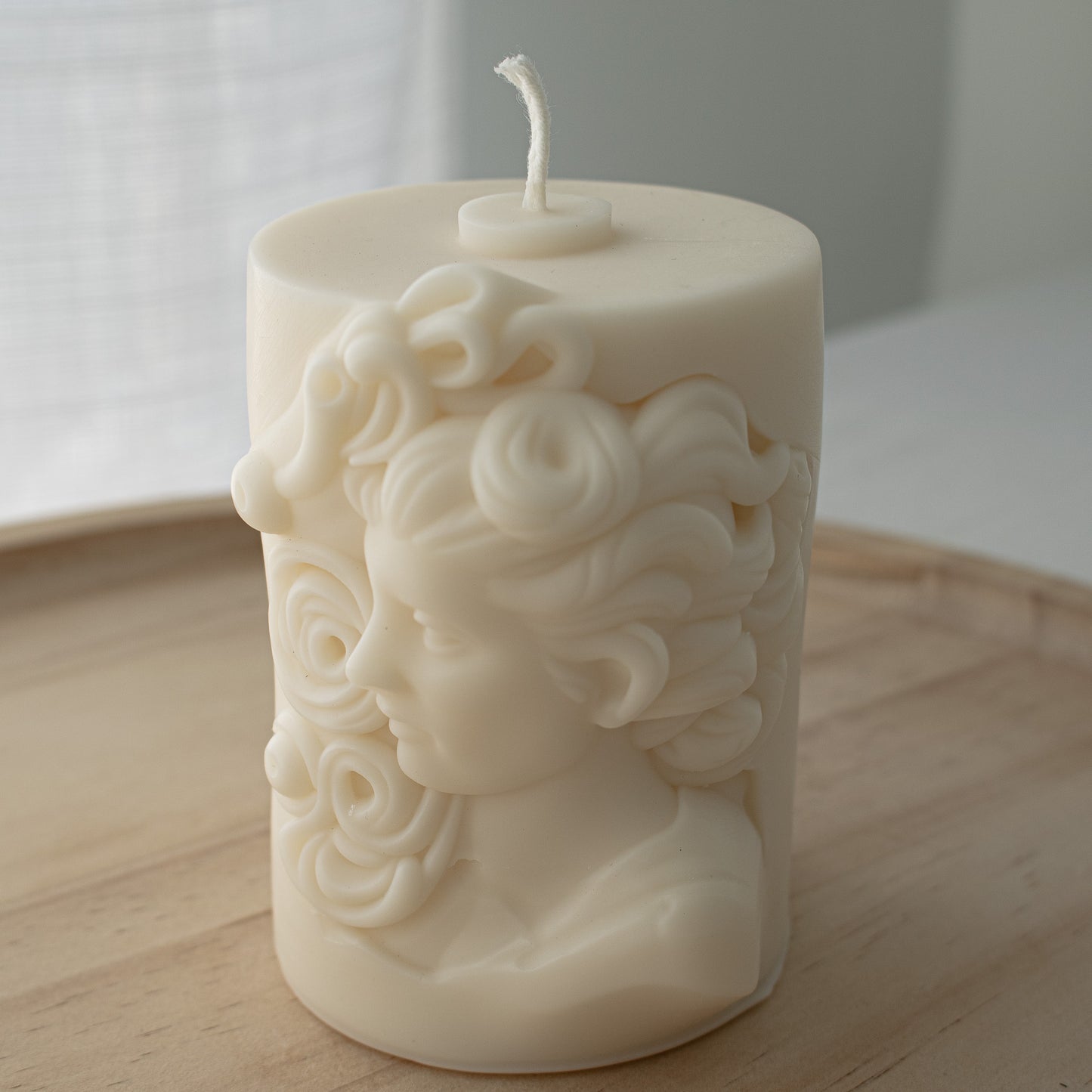 elegant Artisan soy wax candle with a highly detailed Hellenistic Greek woman head sculpted in relief