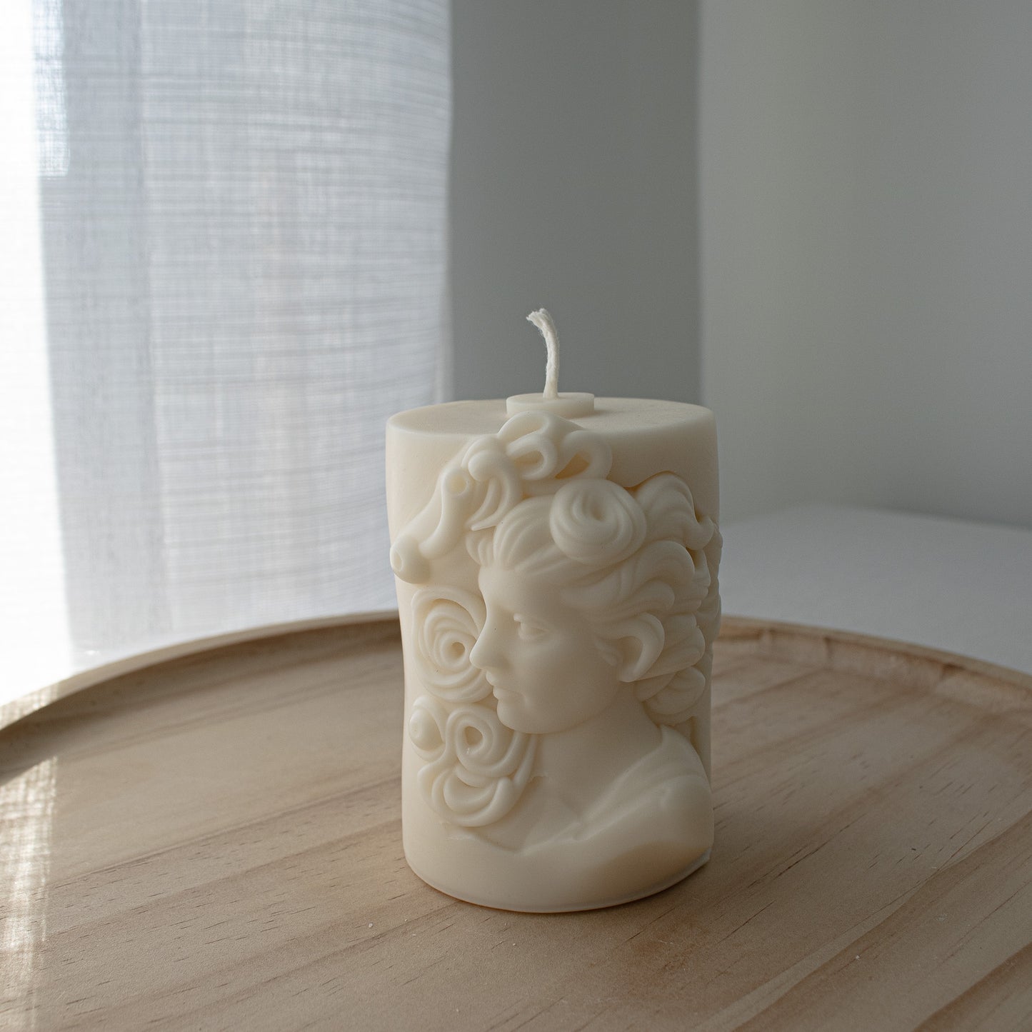 Greek-style soy candle featuring a sculptural bust of a woman in classical form