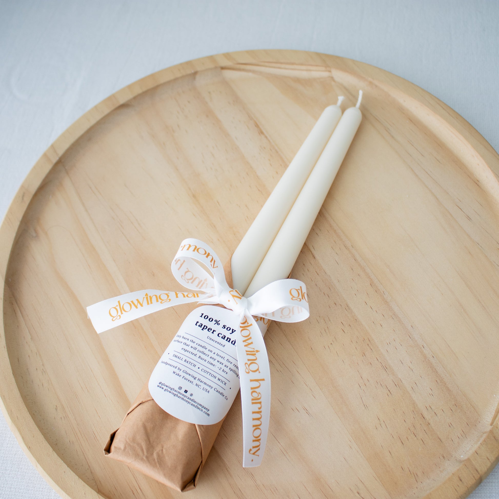White soy candle wrapped in a ribbon with a label