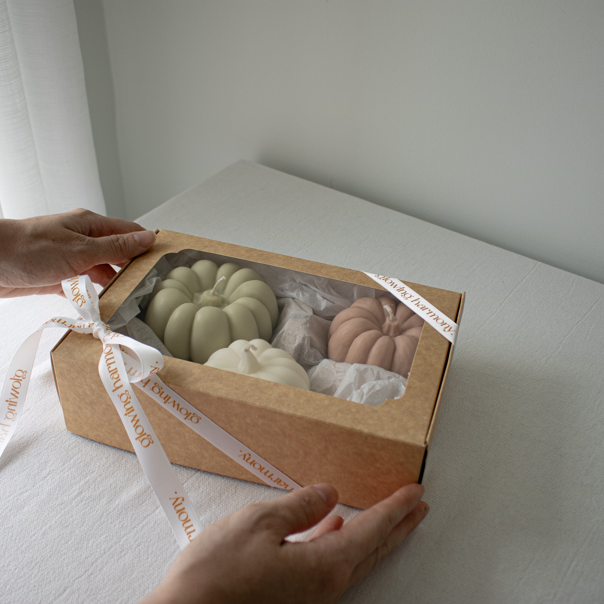 Set of three pumpkin candles nestled in kraft packaging