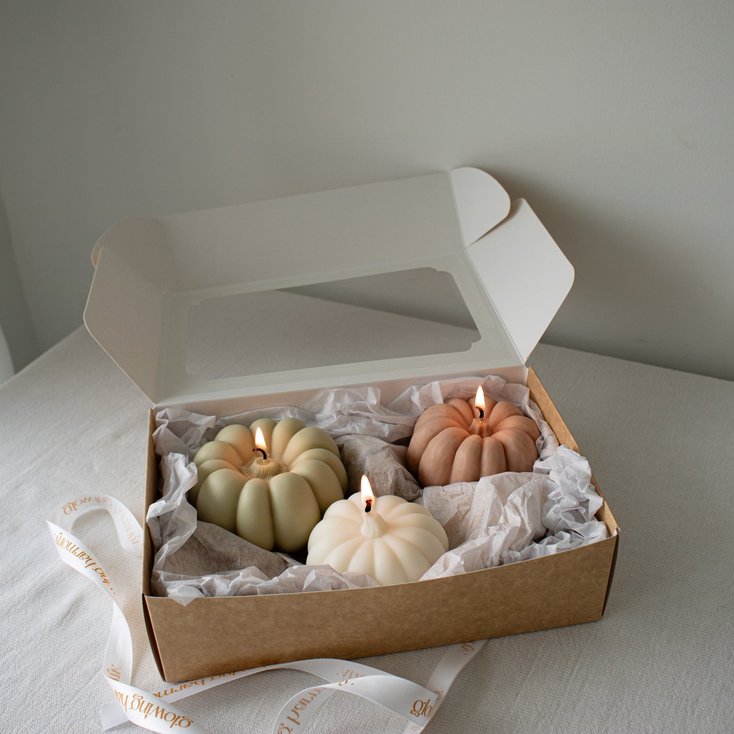 Artisan pumpkin candles displayed in a holiday-ready gift box