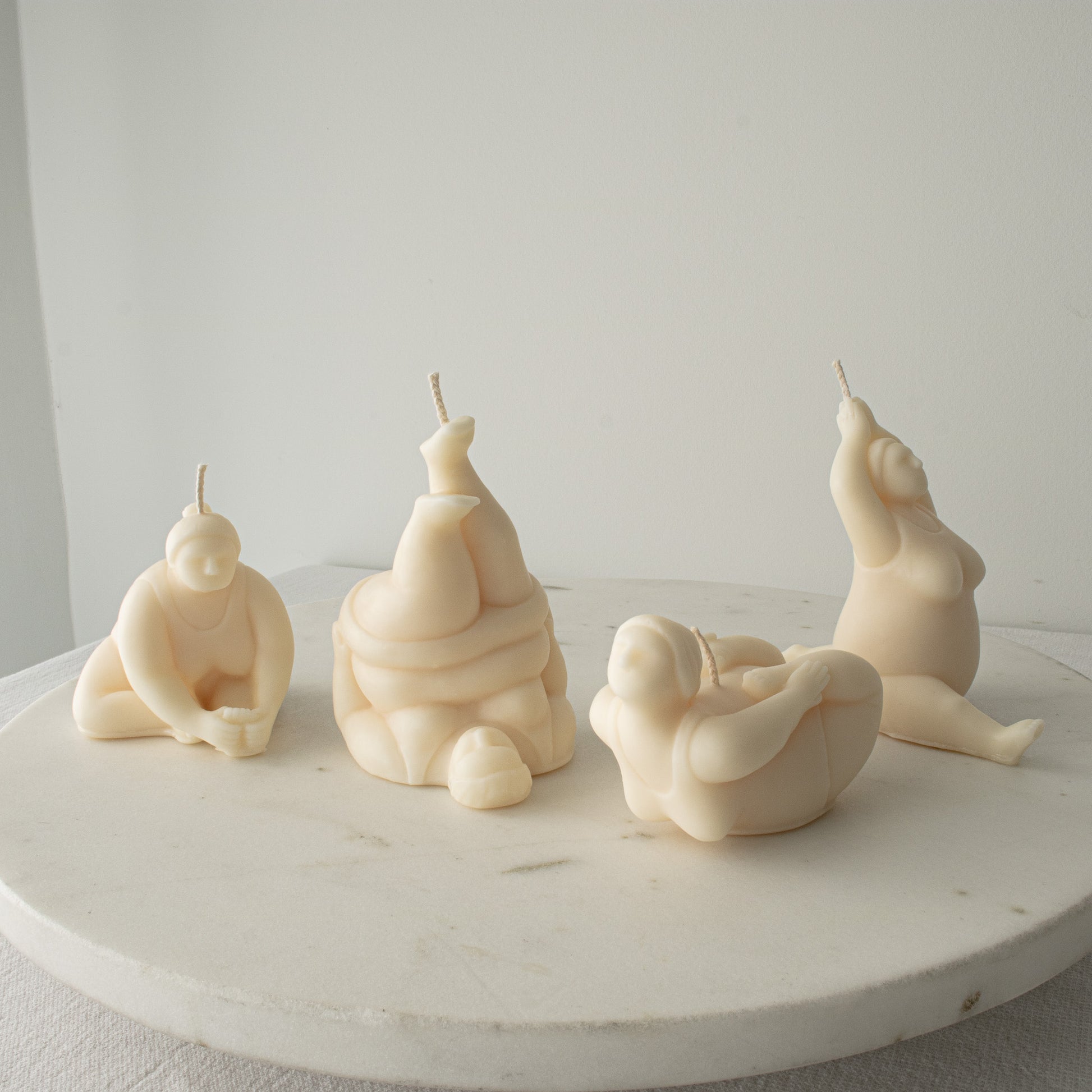 Set of four unique candle sculptures in yoga poses