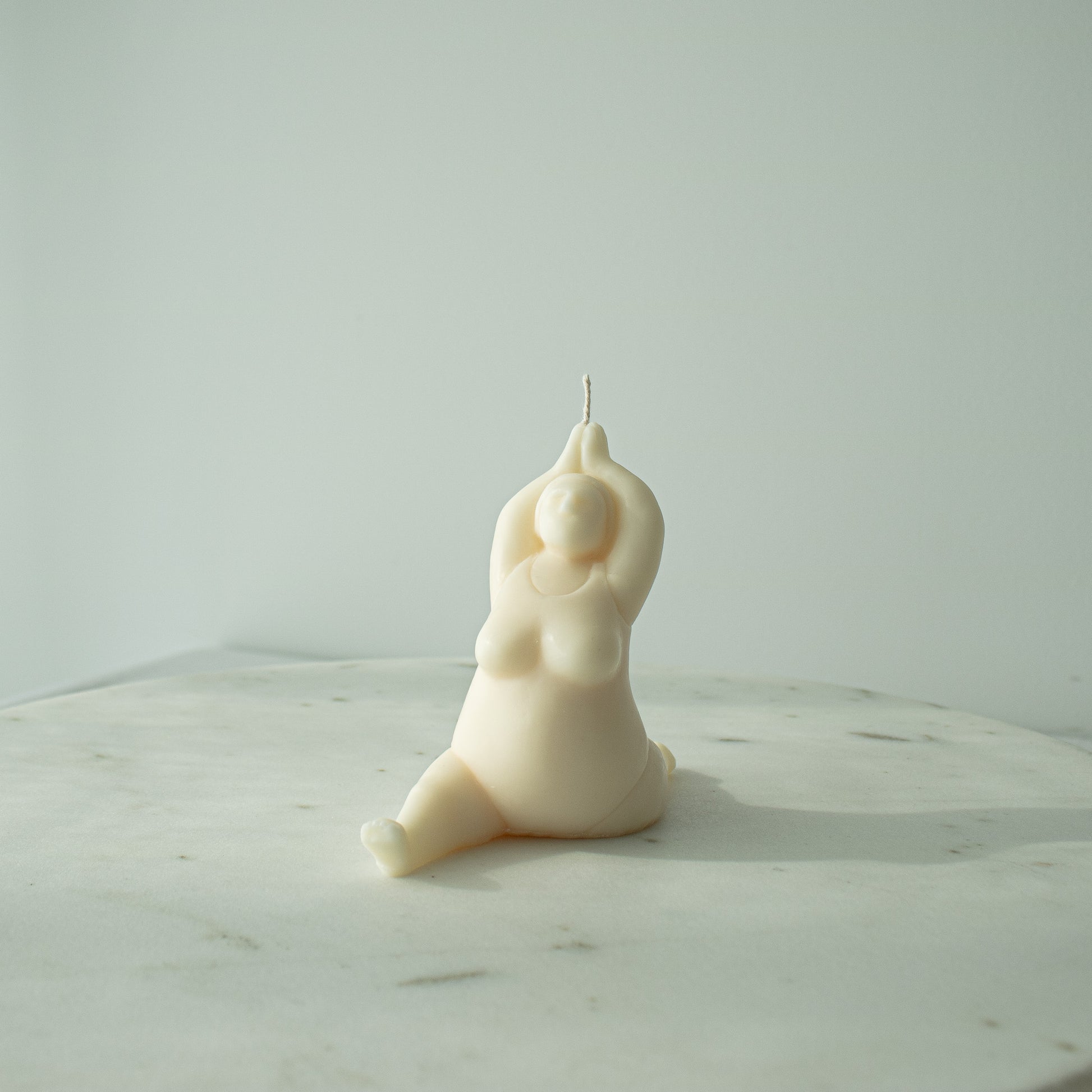 Candle shaped like a person in a meditative pose