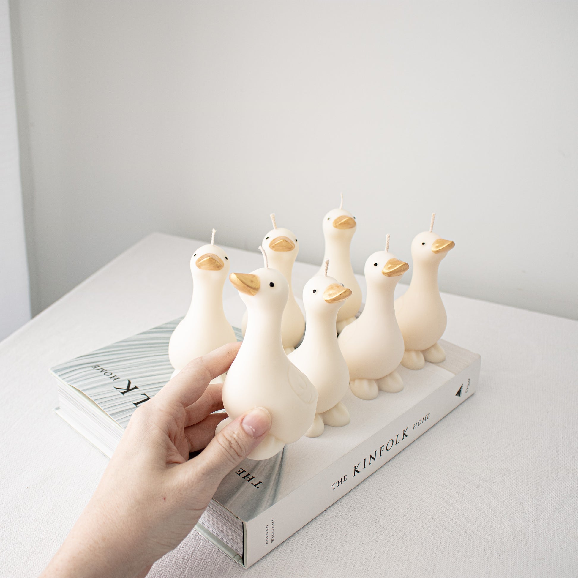 Handmade decorative goose candles with elegant gold beaks, perfect for shelf styling and home accents