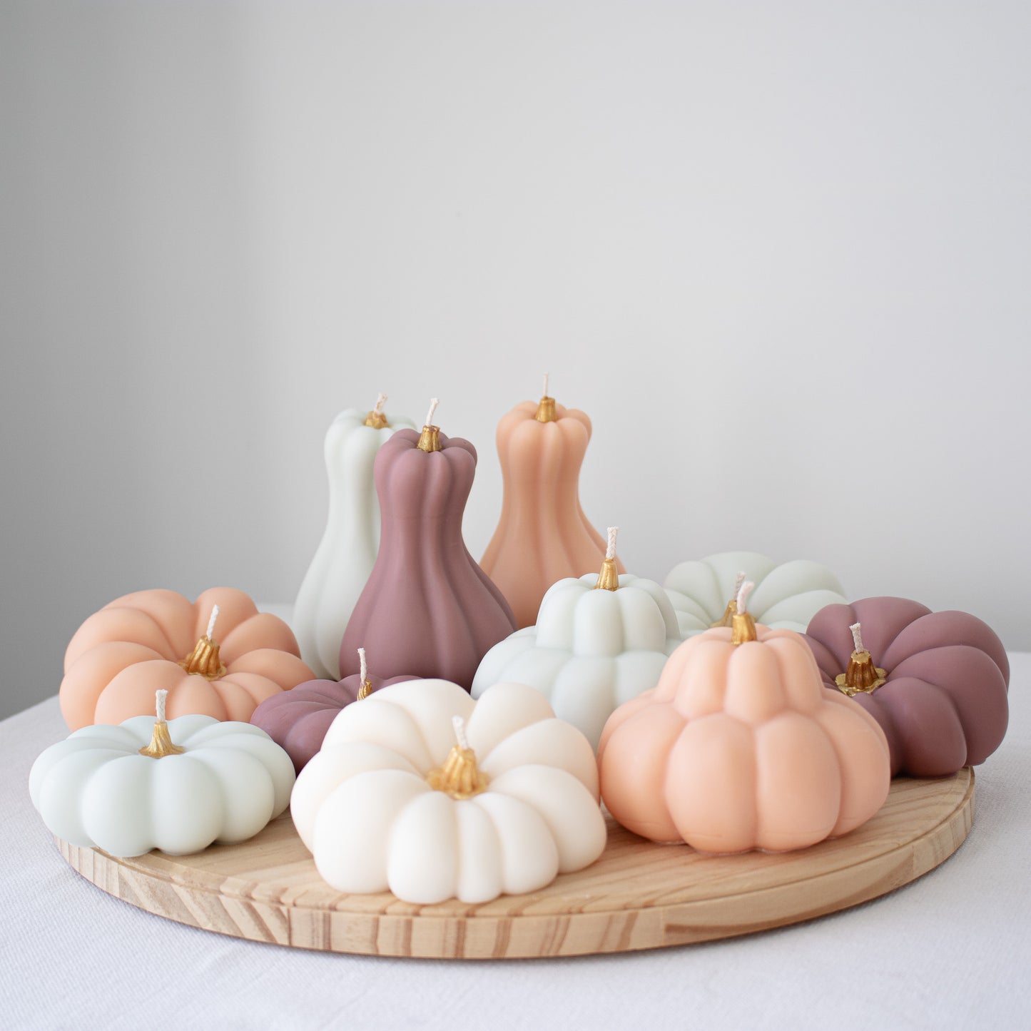 Set of pastel pumpkin decorative candles with gold-painted stems