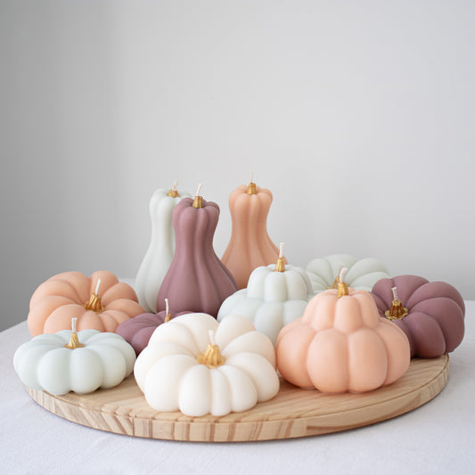 Set of pastel pumpkin decorative candles with gold-painted stems